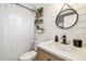Stylish bathroom with ship lap walls, decor shelving, round mirror and sleek fixtures, offering a spa-like experience at 1005 Monroe St, Plant City, FL 33565