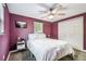 Cozy bedroom with plum walls, white bedding, and a double-door closet at 1005 Monroe St, Plant City, FL 33565