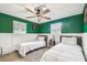 Bright bedroom with white wainscoting, two twin beds, ceiling fan and large windows, providing a refreshing space at 1005 Monroe St, Plant City, FL 33565