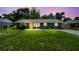 Charming home featuring a yellow door, well-maintained lawn, and lush green bushes at 1005 Monroe St, Plant City, FL 33565