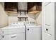 Efficient laundry area with Whirlpool washer and dryer, complemented by upper cabinets for organized storage at 1005 Monroe St, Plant City, FL 33565
