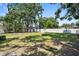Spacious backyard featuring lush lawn, mature trees, and a privacy fence, creating a serene outdoor space at 1013 N Bask Dr, Tampa, FL 33603