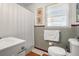 Bathroom featuring a sink, toilet, updated tiling, shower with curtain, and a bright window at 1013 N Bask Dr, Tampa, FL 33603