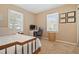 Cozy bedroom featuring neutral tones, a dedicated workspace, and natural light from two windows at 1013 N Bask Dr, Tampa, FL 33603