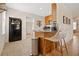 Compact kitchen with oak cabinets, breakfast bar, tile flooring, and stainless steel appliances at 1013 N Bask Dr, Tampa, FL 33603