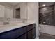 Bathroom featuring double sinks with stone counters and tile surround at 10517 Crestview Heights Ave, Thonotosassa, FL 33592