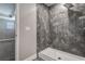 Close up of tiled shower with glass door in bathroom with wood-look flooring at 10517 Crestview Heights Ave, Thonotosassa, FL 33592