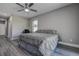 Cozy bedroom featuring wood-look floors, a ceiling fan, and a comfortable bed with gray bedding at 10517 Crestview Heights Ave, Thonotosassa, FL 33592