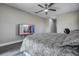 Bedroom showcases a TV, ceiling fan, and a comfortable bed with stylish gray bedding at 10517 Crestview Heights Ave, Thonotosassa, FL 33592