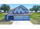 Charming two-story home featuring a three-car garage, manicured landscaping, and a stone-accented porch at 10517 Crestview Heights Ave, Thonotosassa, FL 33592