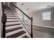 Staircase with dark wood and white trim, leading to an open living space with ample natural light at 10517 Crestview Heights Ave, Thonotosassa, FL 33592