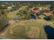 Aerial view of lush golf course landscape featuring ponds, sand traps, and beautiful red-roofed homes at 1065 Tartan Dr # C, Palm Harbor, FL 34684