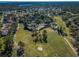 Aerial view of a golf course lined with trees, homes, and a pond in a beautiful residential neighborhood at 1065 Tartan Dr # C, Palm Harbor, FL 34684