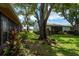 Well-maintained backyard with mature trees, lush landscaping, and beautiful green space at 1065 Tartan Dr # C, Palm Harbor, FL 34684