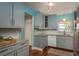 Charming kitchen featuring blue cabinets, granite counters, and modern appliances at 1065 Tartan Dr # C, Palm Harbor, FL 34684