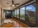 Bright sun room with hardwood flooring, lots of natural light, and views of landscaped grounds at 1065 Tartan Dr # C, Palm Harbor, FL 34684
