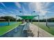 Shaded seating area between tennis courts, ideal for relaxing and watching matches at 1065 Tartan Dr # C, Palm Harbor, FL 34684