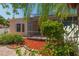 View of screened lanai from the yard, with mature shrubbery and vibrant mulch at 1126 Haley Ln, Dunedin, FL 34698
