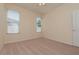 Serene carpeted bedroom featuring two windows, perfect for relaxation and comfortable living at 1126 Haley Ln, Dunedin, FL 34698
