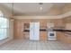 Sun-lit kitchen with an abundance of cabinets, stainless steel refrigerator, and tile flooring at 1126 Haley Ln, Dunedin, FL 34698