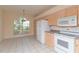 Well-equipped kitchen with stainless steel appliances, wood cabinets, and tile flooring at 1126 Haley Ln, Dunedin, FL 34698