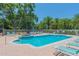 Sparkling community pool with surrounding lounge chairs, tables, and a jacuzzi for relaxing resort style living at 1126 Haley Ln, Dunedin, FL 34698