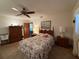 Bedroom with ceiling fan, decorative bedding, and a window with sheer curtains at 11430 Nature Trl, Port Richey, FL 34668