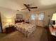 Cozy bedroom with a ceiling fan, decorative bedding, and a window with sheer curtains at 11430 Nature Trl, Port Richey, FL 34668