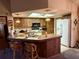 Open kitchen with wood cabinets, skylight, white refrigerator, and breakfast bar with seating at 11430 Nature Trl, Port Richey, FL 34668