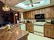 Bright kitchen with wood cabinets, a drop in oven, black microwave, and a skylight above at 11430 Nature Trl, Port Richey, FL 34668