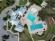 Aerial view of the community pool featuring a splash pad, lap pool, lounge seating, and clubhouse at 13103 Monach Isles Dr, Riverview, FL 33579