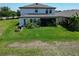 Expansive backyard features a screened in patio, manicured lawn, and lush, tropical landscaping at 13103 Monach Isles Dr, Riverview, FL 33579