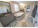 Spacious bathroom with a large soaking tub, double vanity, and neutral tile flooring at 13103 Monach Isles Dr, Riverview, FL 33579
