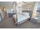 Elegant bedroom with a four-poster bed, plush bedding, and neutral decor at 13103 Monach Isles Dr, Riverview, FL 33579