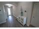 Inviting entryway features elegant decor, a decorative cabinet, and stylish chandelier and gray wood floors at 13103 Monach Isles Dr, Riverview, FL 33579