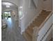 Inviting hallway featuring wood-look tile flooring, staircase, and an open view of the living area at 13103 Monach Isles Dr, Riverview, FL 33579