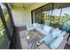 Enclosed lanai featuring a comfortable blue outdoor seating area and views of the pond at 13103 Monach Isles Dr, Riverview, FL 33579
