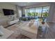 Bright living room with a white sofa, large windows with lake view, and neutral decor at 13103 Monach Isles Dr, Riverview, FL 33579