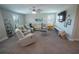 Bright living room with a sectional sofa, a ceiling fan, and large windows at 13103 Monach Isles Dr, Riverview, FL 33579