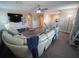 Open living area featuring a large curved sofa, TV, and staircase to the upper level at 13103 Monach Isles Dr, Riverview, FL 33579