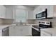 Well-lit kitchen with stainless steel appliances, ample cabinetry, and modern countertops at 13640 Forest Lake Dr, Largo, FL 33771