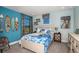 Vibrant bedroom with surf-themed decor, bright blue walls, and a comfortable white bed at 13722 Heartwood Way, Parrish, FL 34219