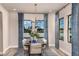 Well-lit dining room with elegant lighting fixture, neutral-toned furnishings, and large windows overlooking a serene lake at 13722 Heartwood Way, Parrish, FL 34219