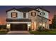 Elegant two-story home featuring stone accents, a tile roof, and a charming arched entryway and a 2-car garage at 13722 Heartwood Way, Parrish, FL 34219
