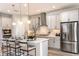 Modern kitchen with stainless steel appliances, a center island with bar seating, and sleek gray cabinets at 13722 Heartwood Way, Parrish, FL 34219