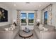Cozy sitting area with plush seating, natural light, and views through a window with patterned curtains at 13722 Heartwood Way, Parrish, FL 34219