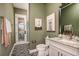 Stylish bathroom with olive green walls, black and white tile floors, and granite countertops at 13726 Heartwood Way, Parrish, FL 34219
