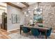 Elegant dining area featuring a stone accent wall, wood beams, and modern chandelier at 13726 Heartwood Way, Parrish, FL 34219