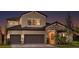 Beautiful two-story home at dusk featuring a brick and stucco facade, and a two-car garage at 13726 Heartwood Way, Parrish, FL 34219
