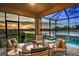Inviting screened lanai with comfortable seating, overlooking the pool and picturesque lake at 13726 Heartwood Way, Parrish, FL 34219